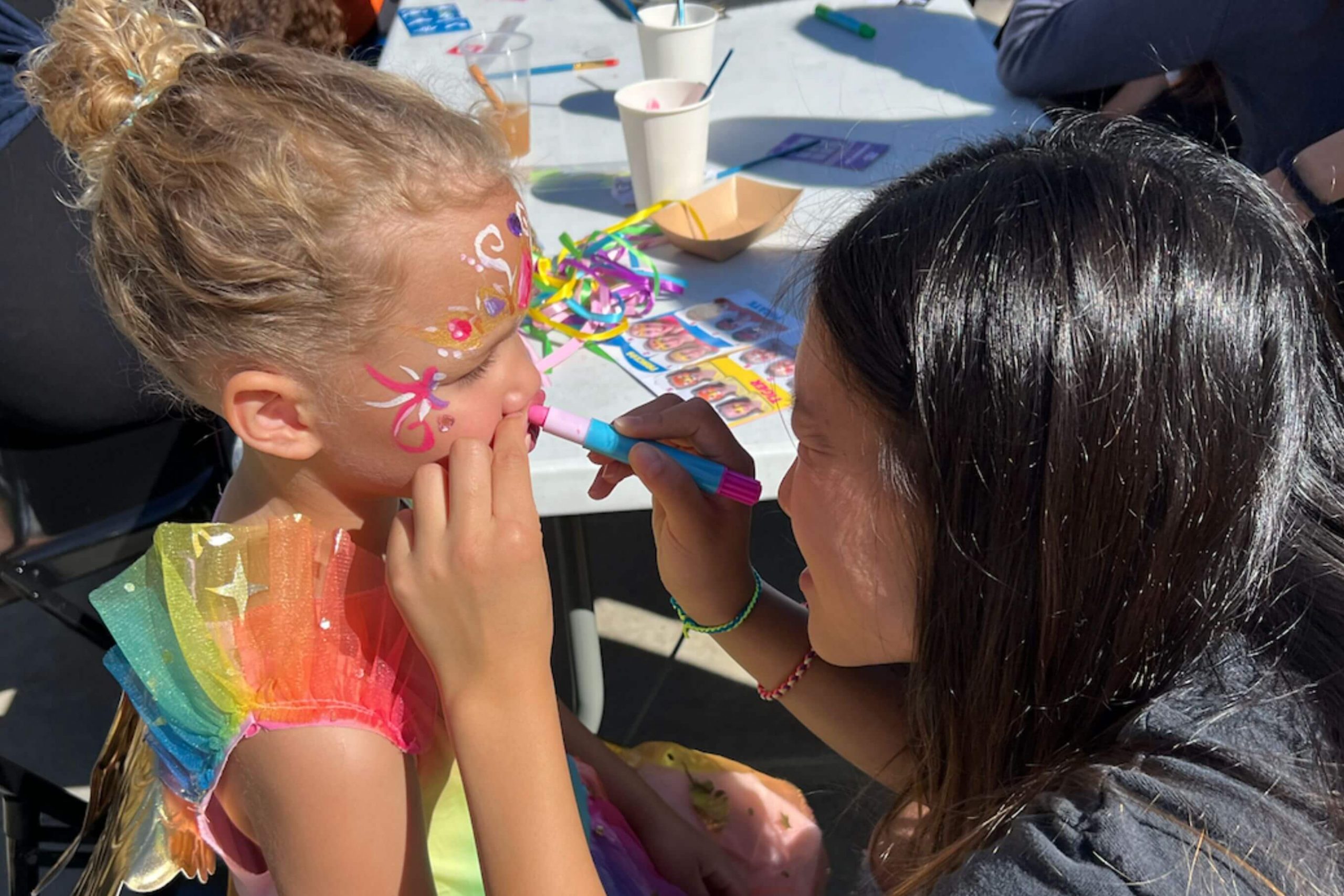 girl getting her face painted with flowers